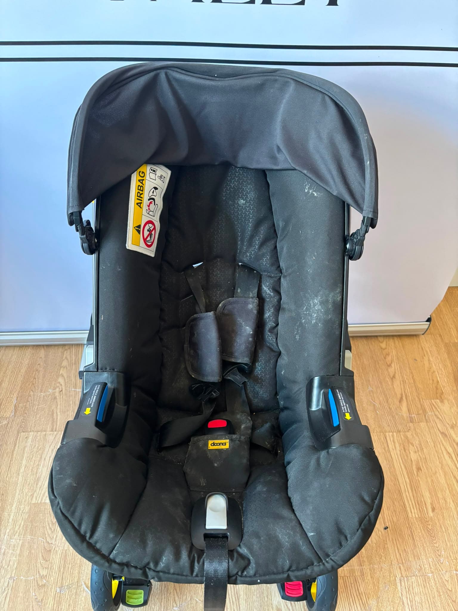 Before cleaning, a Doona pram with everyday marks on the seat and frame.