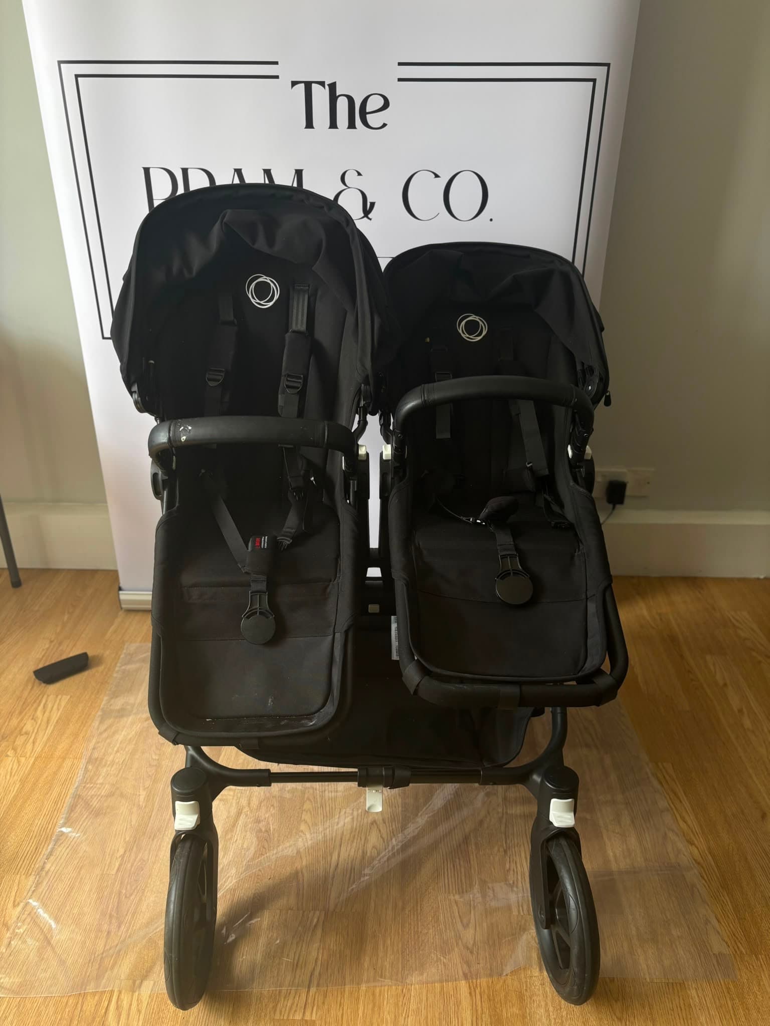Before cleaning, a Bugaboo pram seat and frame with visible everyday marks.